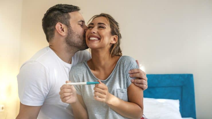Young couple is happy because of positive pregnancy test