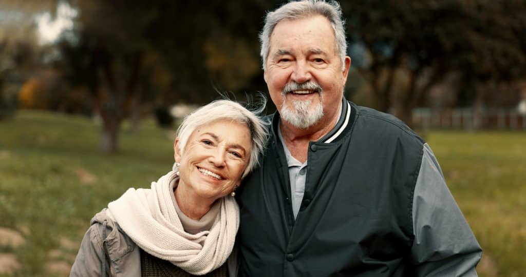 Face love and happy with a senior couple outdoor in a park together for a romantic date during retirement Portrait smile or care with an elderly man and woman bonding in a garden for romance